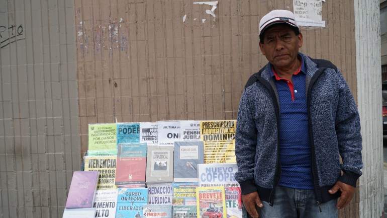 Pedro Tuya Moreno, 52, a political independent in Peru, stands next to books
