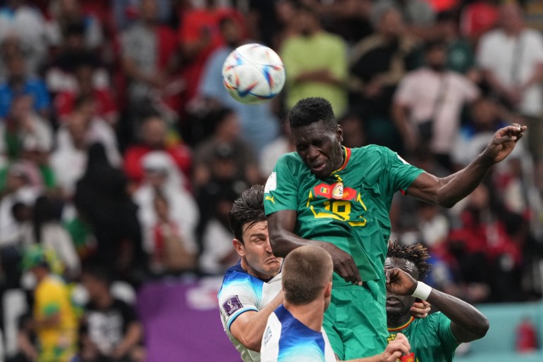 Senegal and England players jump to head the ball during their group of 16 match.