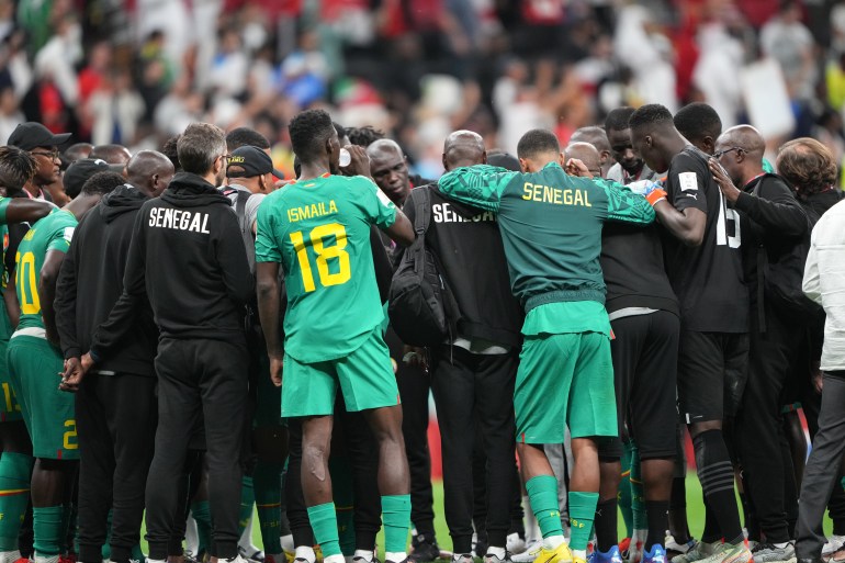 Senegal's team huddles after its loss to England.