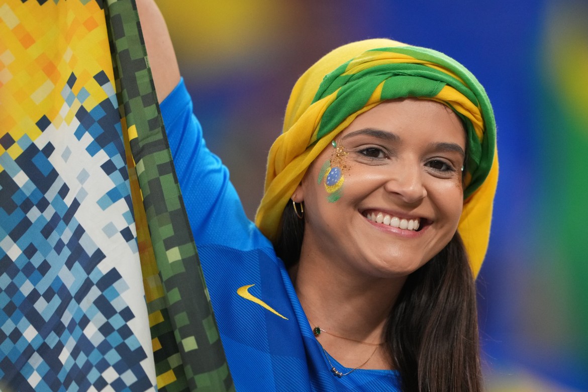 A smiling Brazil fan celebrates in the stands.