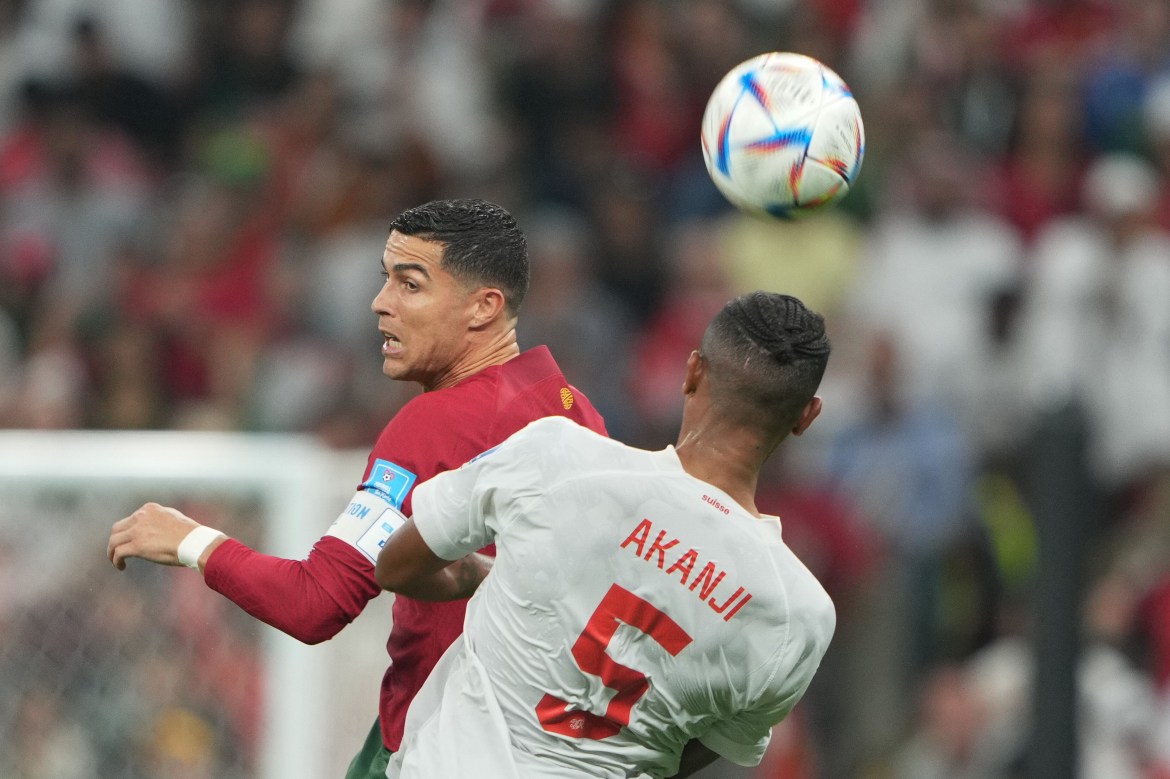 Portugal's Cristiano Ronaldo in action against Switzerland's Manuel Akanji as they both jump up to head the ball.