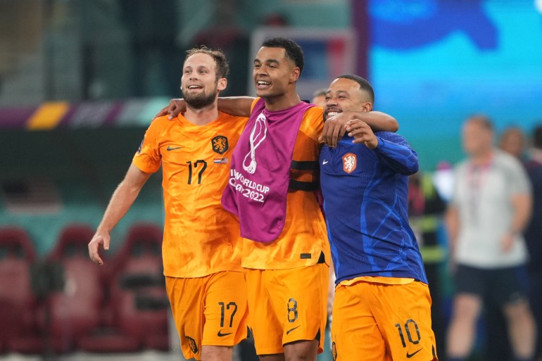 Three players for the Netherlands celebrate on the pitch.