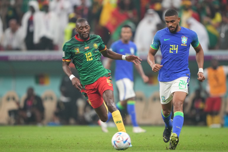 Karl Toko Ekambi #12 in action with Bremer #24 | Cameroon v Brazil, Group G, FIFA World Cup 2022, December 2, Lusail Stadium [Sorin Furcoi/Al Jazeera]
