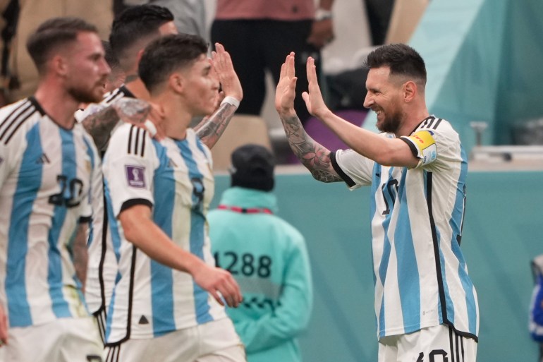 Lionel Messi coming up to his teammates with both palms up for a double high five.