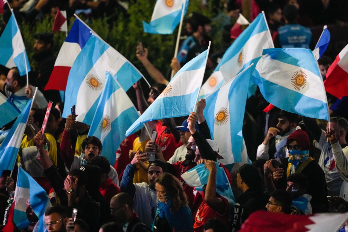 Fans waving Argentina flags are pictured along the parade route following the final game.