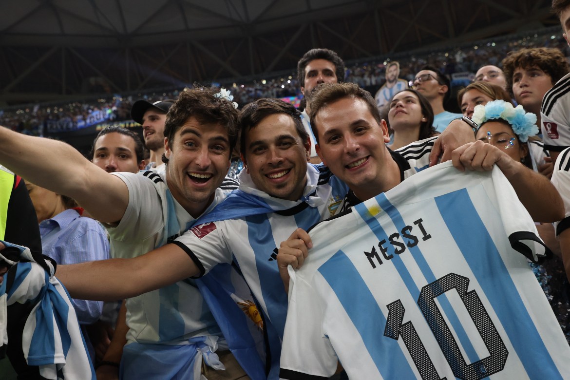 Argentina fans showing off a Messi shirt in the stands.