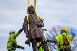 Workers remove a Confederate statue