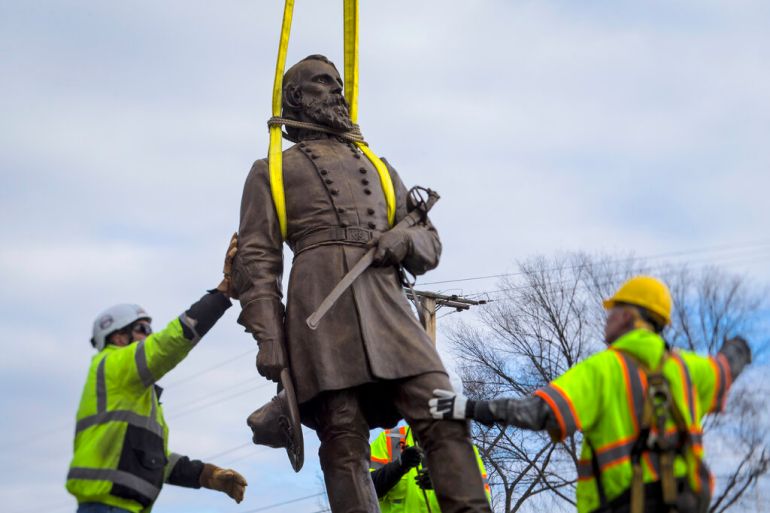 Workers remove a Confederate statue