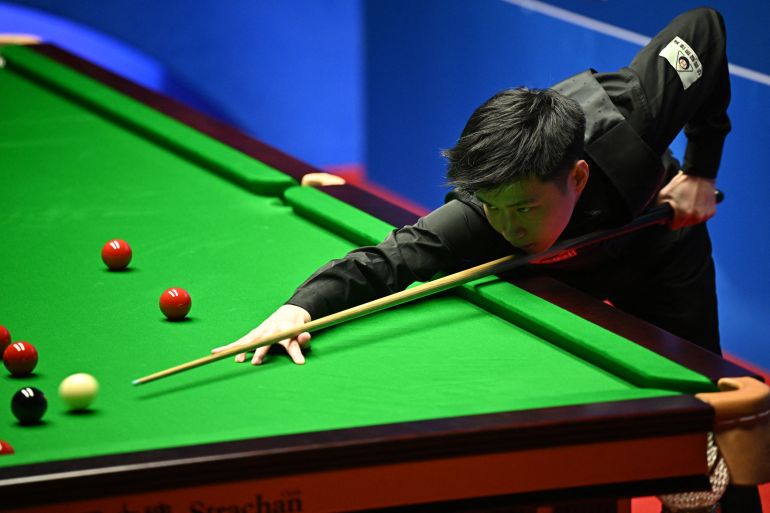 China's Zhao Xintong plays a shot against Scotland's Stephen Maguire during their World Championship Snooker second round match at The Crucible in Sheffield, England on April 22, 2022. (Photo by Oli SCARFF / AFP)