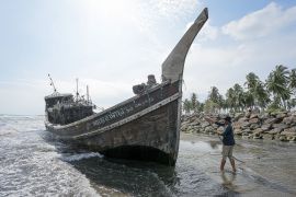 A wooden boat with a prominent bow on the beach in Aceh, Indonesia. Dozens of Rohingya travelled in the boat coming ashore in late December after weeks at sea.