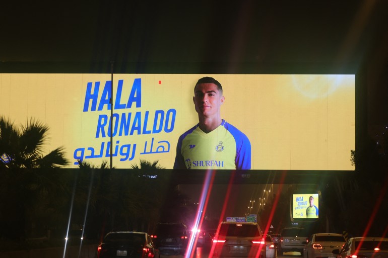 Un panneau d'affichage au-dessus d'une chaussée remplie de voitures accueillant l'arrivée de Cristiano Ronaldo au club Al Nassr d'Arabie.