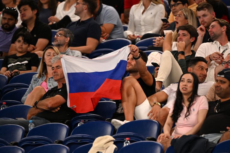 A supporter holds a flag of Russia during the men's singles match between Marcos Giron of the US and Russia's Daniil Medvedev