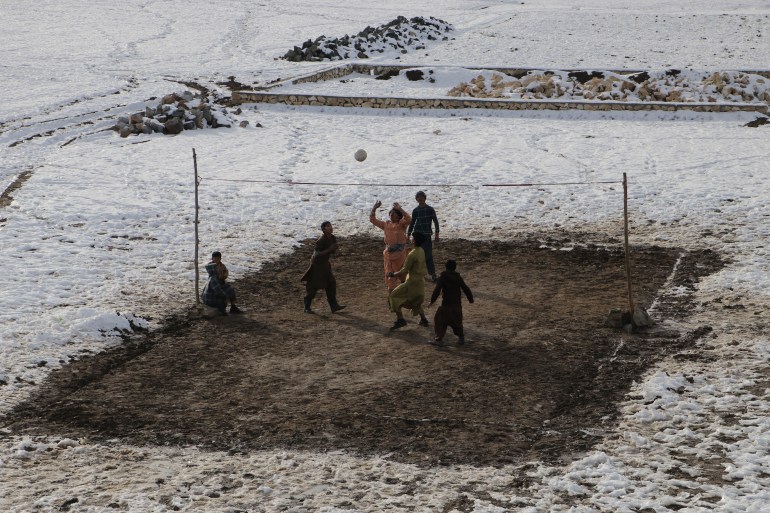 People play volleyball during a cold winter day in Yaftal Sufla district of Badakhshan Province on January 18, 2023. - At least 70 people have died in a wave of freezing temperatures sweeping Afghanistan, officials said on Janaury 18, as extreme weather compounds a humanitarian crisis in the poverty-stricken nation. (Photo by OMER ABRAR / AFP)