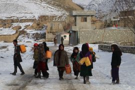 Children carry containers to fetch drinking water along a road during a cold winter day in Yaftal Sufla district of Badakhshan Province on January 18, 2023. - At least 70 people have died in a wave of freezing temperatures sweeping Afghanistan, officials said on Janaury 18, as extreme weather compounds a humanitarian crisis in the poverty-stricken nation. (Photo by OMER ABRAR / AFP)