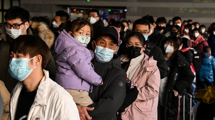 A man holding a child is among passengers queued up at the Beijing West railway station ahead of the Lunar New Year in Beijing, China.