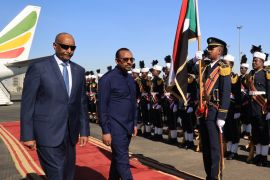 Ethiopian Prime Minister Abiy Ahmed (R) walks alongside Sudanese Army Chief Abdel Fattah al-Burha
