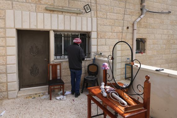 A relative of a Palestinian gunman inspects the barricade put up by Israeli soldiers at the Alqam family home