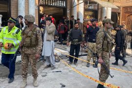 Security personnel cordon off the site of a mosque blast inside the police headquarters in Peshawar [Maaz Ali/ AFP]