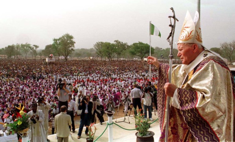 Pope John Paul II waves to the crowd March 23 before the start of a mass in the village of Kubwa on the outskirts of the capital Abuja. This was the final public appearance of the Pope on his three day tour of Nigeria during which urged Nigeria's leader General Sani Abacha to make improvements in the human rights situation. NIGERIA POPE