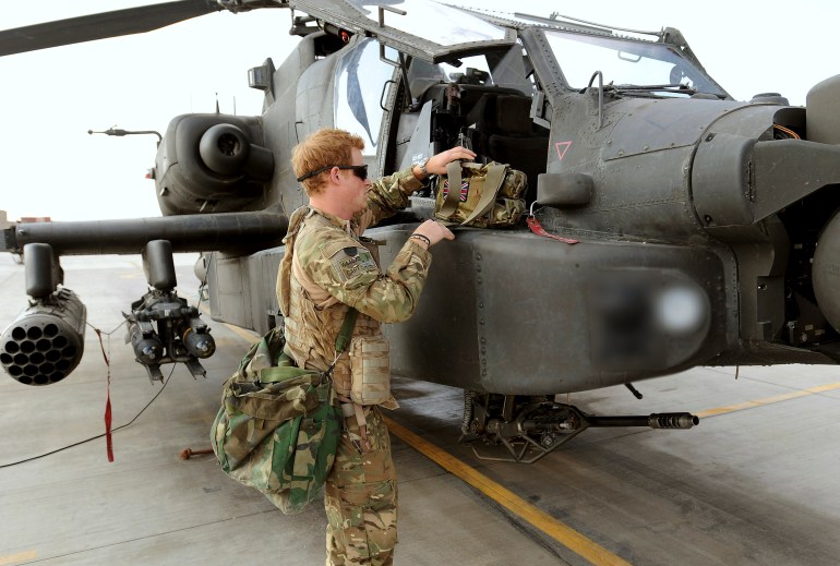 O príncipe Harry da Grã-Bretanha ao lado de seu helicóptero Apache em Camp Bastion, sul do Afeganistão nesta fotografia tirada em 31 de outubro de 2012 e divulgada em 21 de janeiro de 2013. O príncipe, que está servindo como piloto/artilheiro no 662 Squadron Army Air Corps, está em uma postagem no Afeganistão que vai de setembro de 2012 a janeiro de 2013. Fotografia tirada em 31 de outubro de 2012. Fotografia pixelizada na fonte.  REUTERS/John Stillwell/Pool (AFEGANISTÃO - Marcas: CONFLITO DA SOCIEDADE POLÍTICA MILITAR)