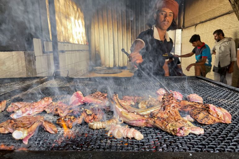 A cook grills meat at a restaurant in Sanaa, Yemen