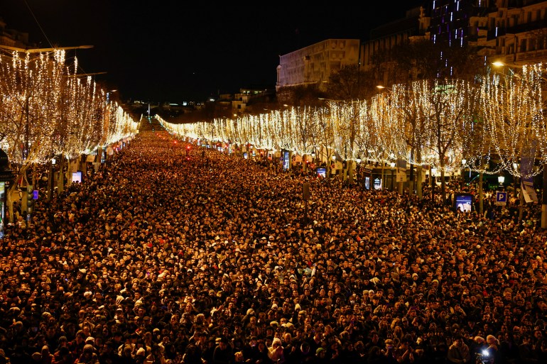 Mensen verzamelen zich op de Champs Elysees Avenue tijdens nieuwjaarsvieringen nabij de Arc de Triomphe in Parijs, Frankrijk, 31 december 2022. REUTERS/Sarah Meyssonnier