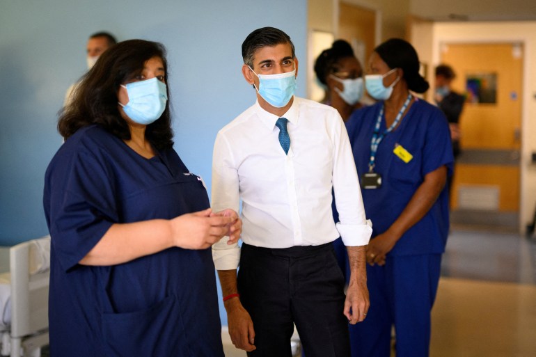 British Prime Minister Rishi Sunak speaks with members of staff as he visits Croydon University Hospital