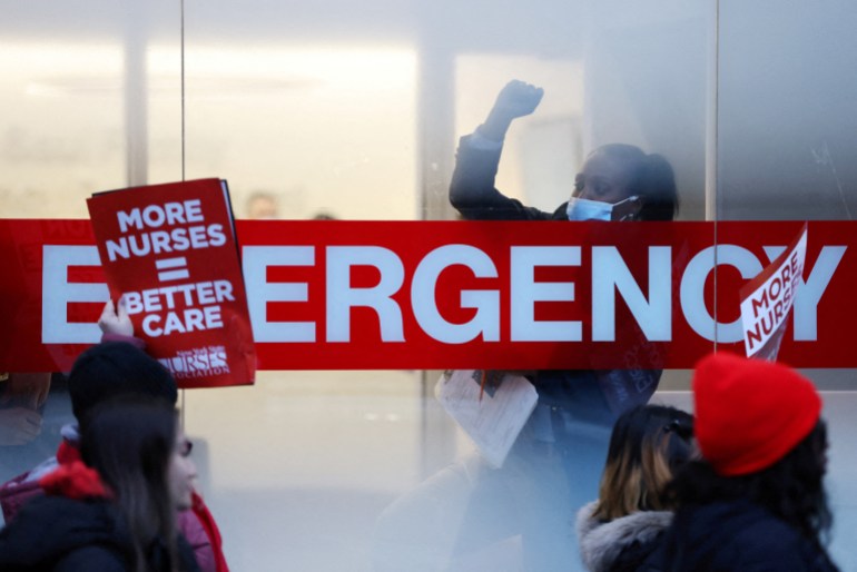A hospital worker raises a fist as New York nurses walk off the job