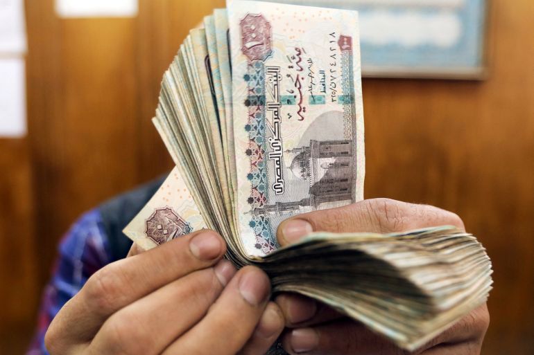An employee counts Egyptian pounds at a foreign exchange office in central Cairo.