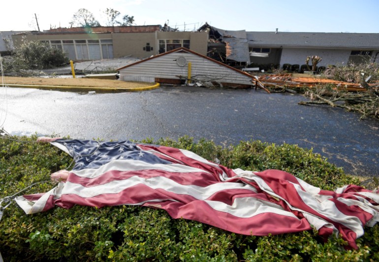 The American flag lies in the shrubs in front of the storm damaged Selma Country Club after a tornado ripped through Selma, Alabama, U.S.