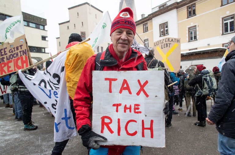 Een klimaatactivist toont een bordje tijdens een protest voorafgaand aan het World Economic Forum (WEF) 2023 in het Alpenresort Davos, Zwitserland, 15 januari 2023. REUTERS/Arnd Wiegmann
