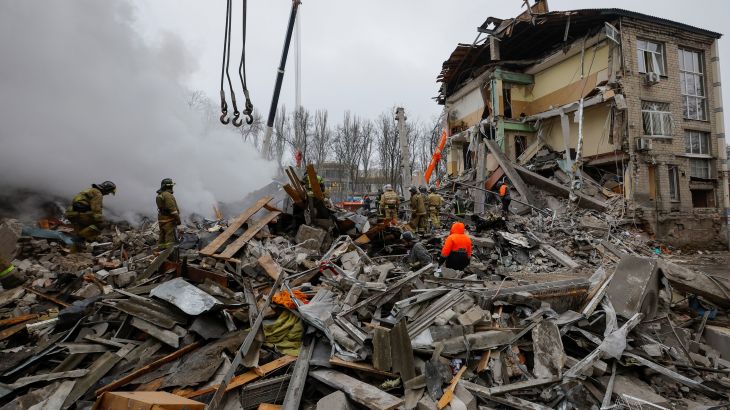 Emergency personnel work among debris at the site where a building was heavily damaged in recent shelling in Donetsk, Russian-controlled Ukraine