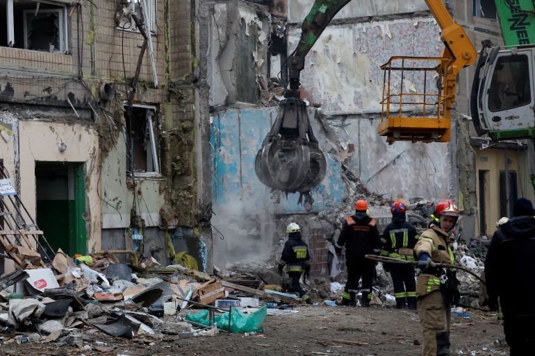 Emergency personnel work at the site where an apartment block was heavily damaged by a Russian missile strike