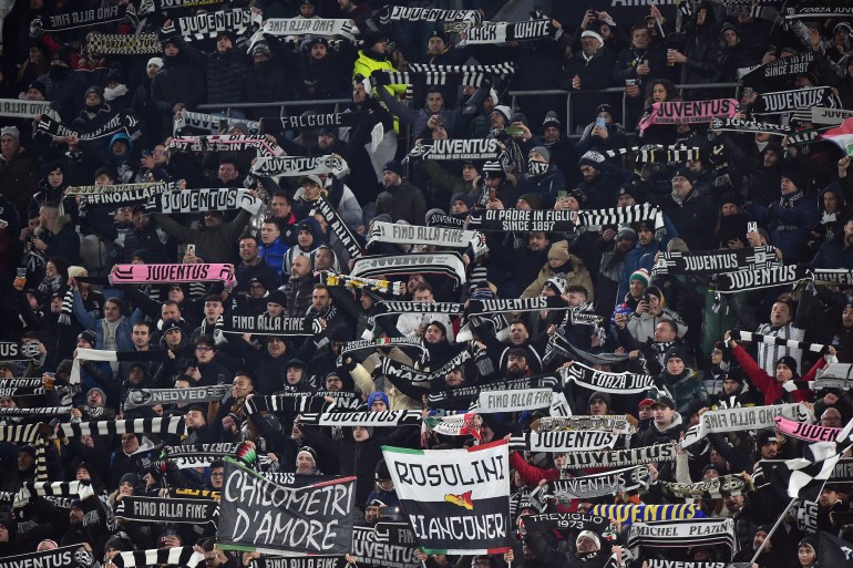 Juventus fans hold their scarves aloft 