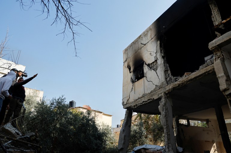 Palestinians inspect a damaged house following an Israeli raid in Jenin