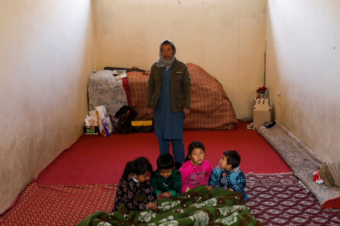 Ashour Ali, 30, with his children poses for a photograph in his house in Kabul