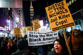 People carry a banner and signs during a protest in New York City, US, on January 27, 2023, the day that authorities released a harrowing video showing Memphis police beating Tyre Nichols, who later died from his injuries [Andrew Kelly/Reuters]