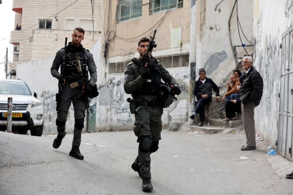 Israeli border police officers walk outside the house of Palestinian gunman Khaire Alkam in occupied East Jerusalem.