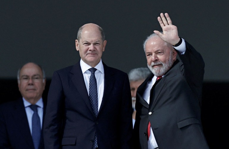 Brazilian President Luiz Inacio Lula da Silva waves as he meets with German Chancellor Olaf Scholz in Brasilia