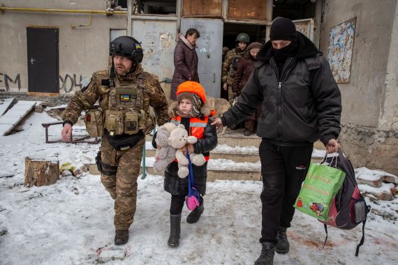 Ukrainian sevicemen help a child leave Bakhmut
