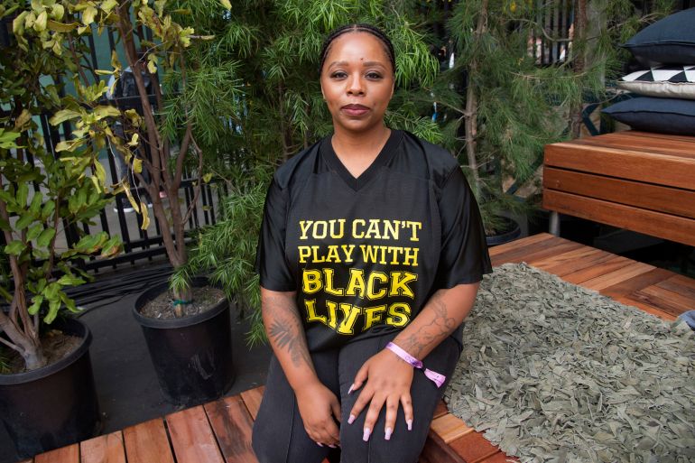 Patrisse Cullors poses for a photo with a shirt that reads: You can't play with Black lives