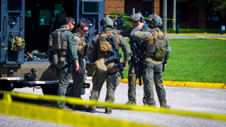 Members of the Virginia State Police SWAT Team gather behind a Bearcat tactical vehicle after clearing Heritage High School in Newport News, Va., Monday, Sept. 20, 2021, following a shooting at the school. (AP Photo/John C. Clark)