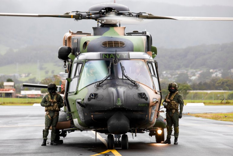 Les équipages de la Royal Australian Navy du 808 Squadron se tiennent à côté de leur hélicoptère MRH90 Taipan à Wollongong, en Australie, en novembre 2021. L'Australie abandonnera sa flotte de Taipans de conception européenne et achètera à la place des Black Hawks américains [File: Kylie Gibson/ADF via Associated Press Photo