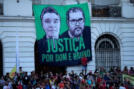 A black-and-green banner calling for justice "for Dom and Bruno" hangs outside a building.