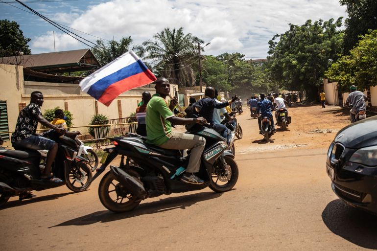 Supporters of Capt Ibrahim Traore parade waving a Russian flag in the streets of Ouagadougou