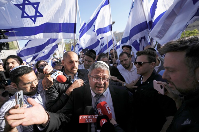 Israeli MP Itamar Ben-Gvir, center, surrounded by right-wing activists holding Israeli flags, speaks to the media as they gather for a march in Jerusalem, Wednesday, April 20 2022. Major Jewish-American organizations, traditionally pro-Israel platforms, have expressed alarm over the supposed government's far-right figure.  Given the predominantly liberal political views of American Jews and friendly relations with the Democratic Party, these suspicions could have a spillover effect in Washington and deepen what has become a partisan divides over pro-Israel.  (AP Photo/Ariel Schalit, File)