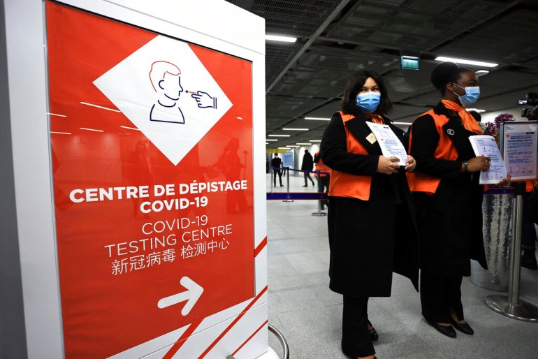 Airport staff wait for passengers arriving from China for a COVID-19 testing area at Roissy Charles de Gaulle airport, north of Paris, Sunday, January 1, 2023. France says it will require negative COVID-19 tests from all passengers arriving from China and urges French citizens to avoid non-essential travel to China.  (AP Photo/Aurelien Morissard)