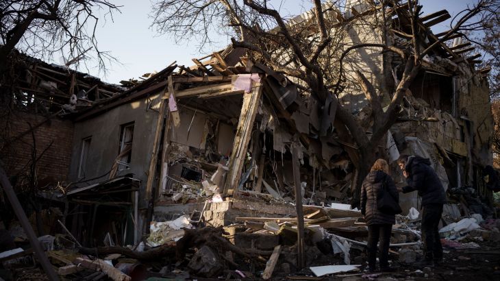 Serhii Kaharlytskyi, right, stands outside his home, destroyed after a Russian attack in Kyiv