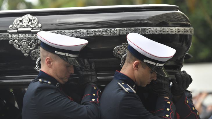 Men in military uniform carry Pele's black casket