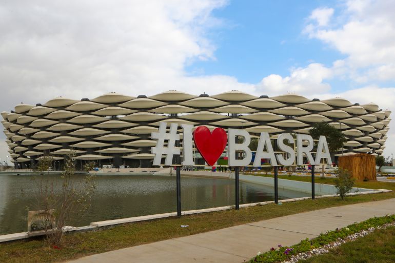 Large white letters and a red heart shape spell out 'I love Basra' in front of a newly built stadium that will host the Arabian Gulf Cup in Basra, Iraq.